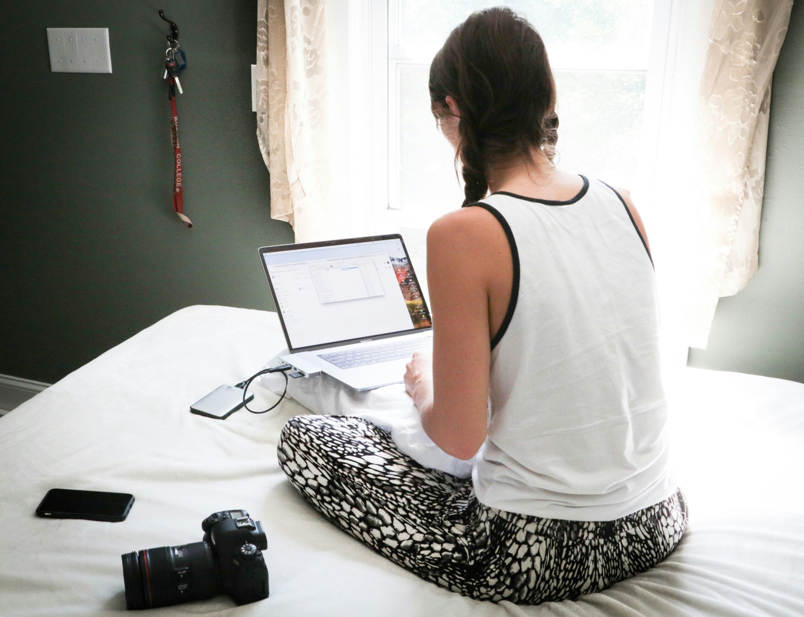 Student working on laptop in bedroom