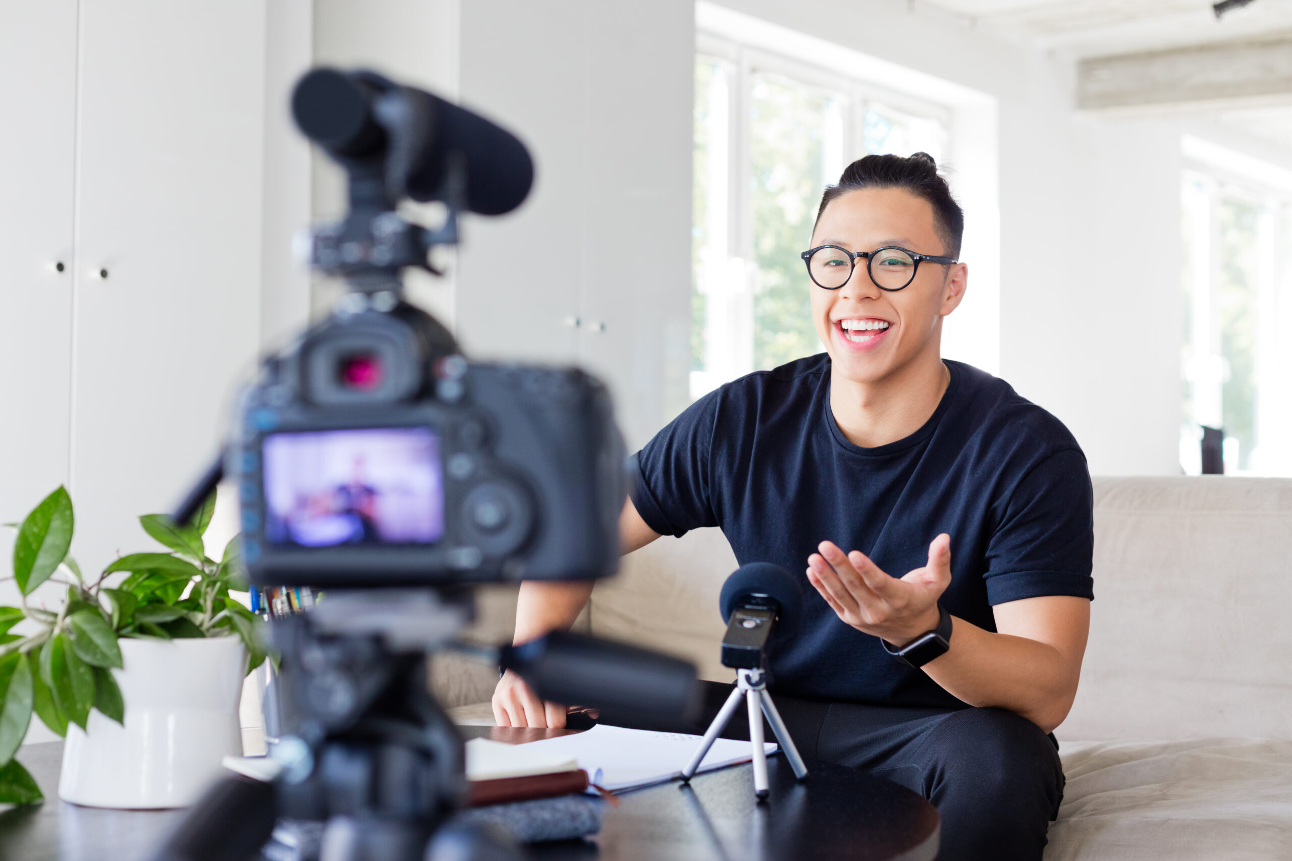 Handsome asian young man making a video blog. Male vlogger recording content on digital camera.